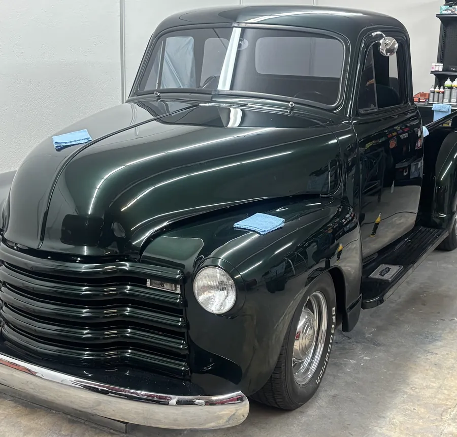Dark green Chevrolet 3100 pickup in the detail bay
